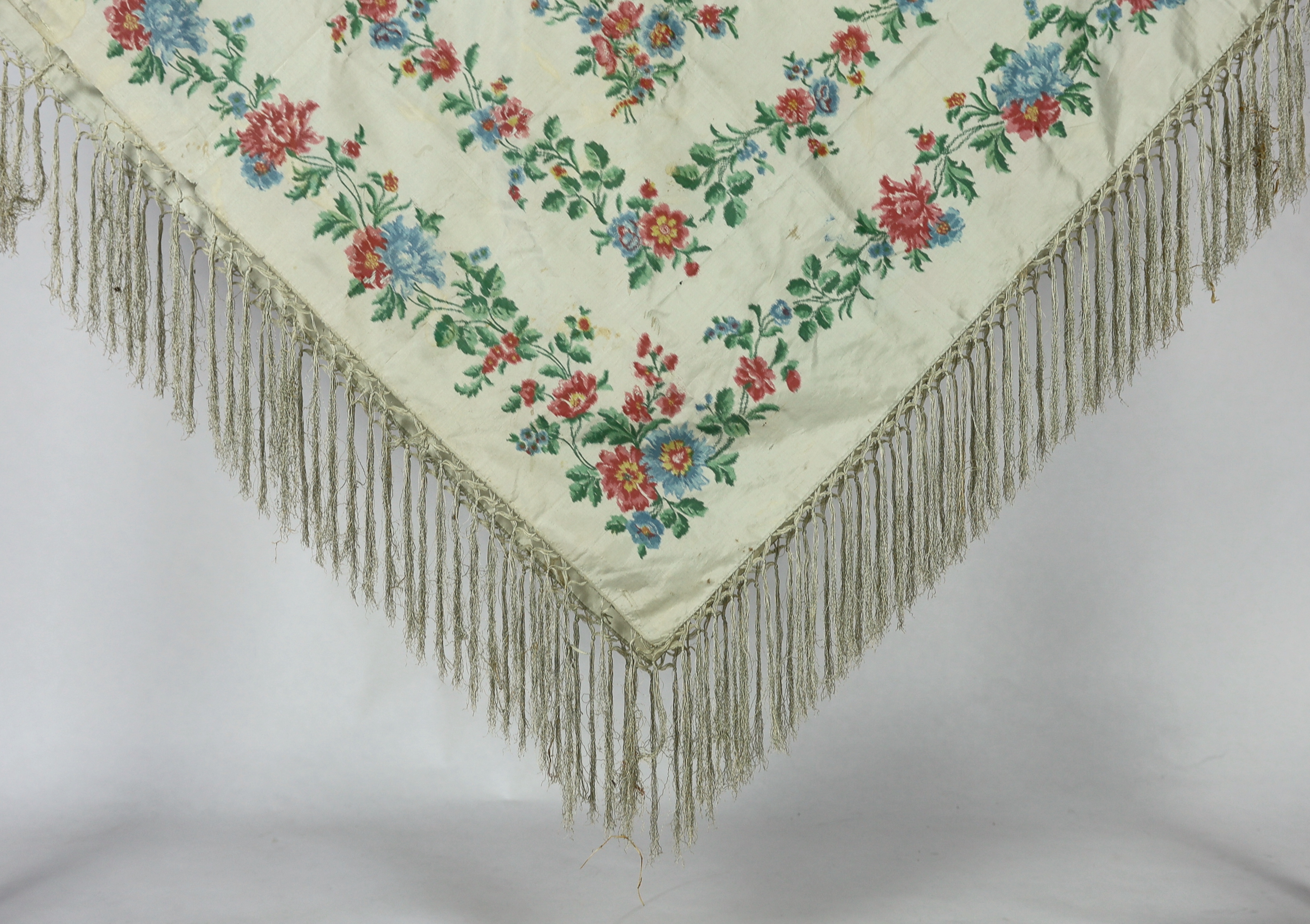 A French silk shawl, c.1800-1840, of a type modelled by Madame Recamier in the painting by François Gerard, printed on the warp thread into a rose pattern, with long fringing, 174 x 170cm